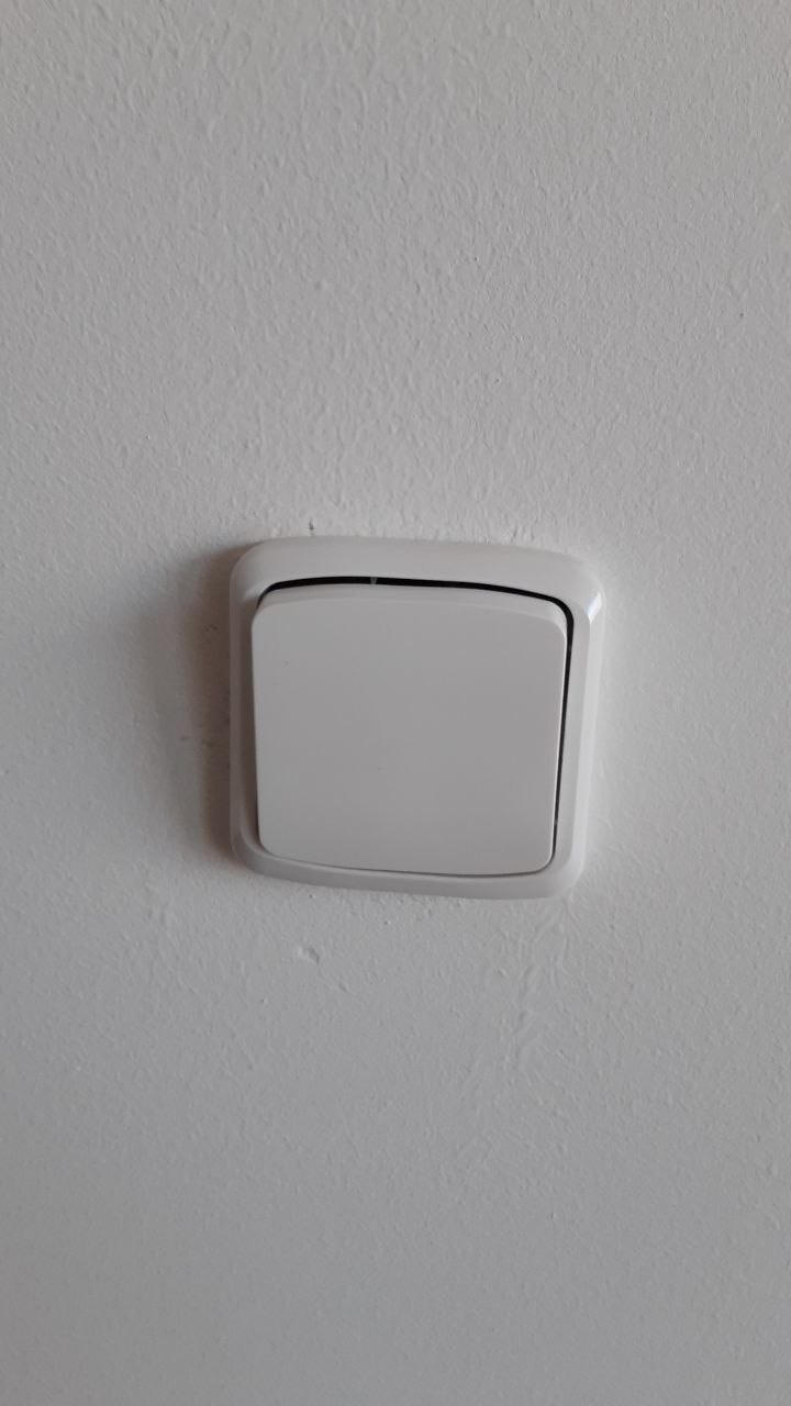 Nově osazený vypínač na hladké stěně