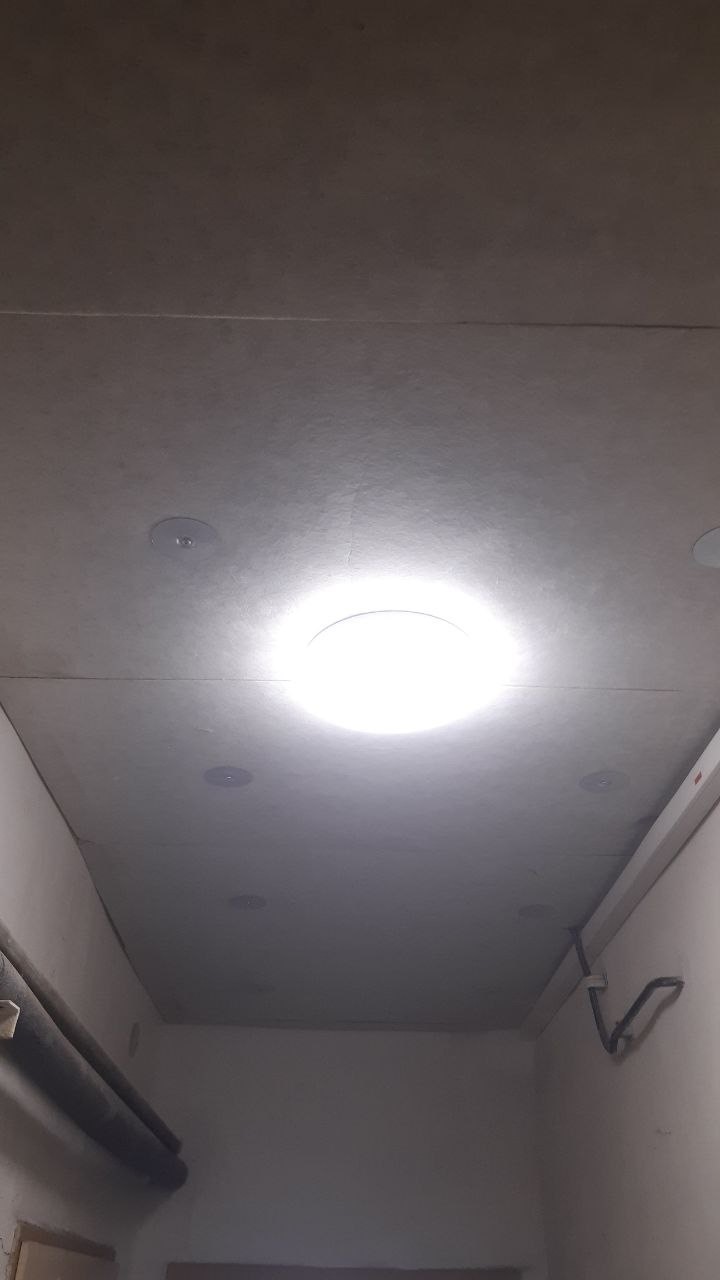 Rozsvícené LED svítidlo na stropě sklepní chodby